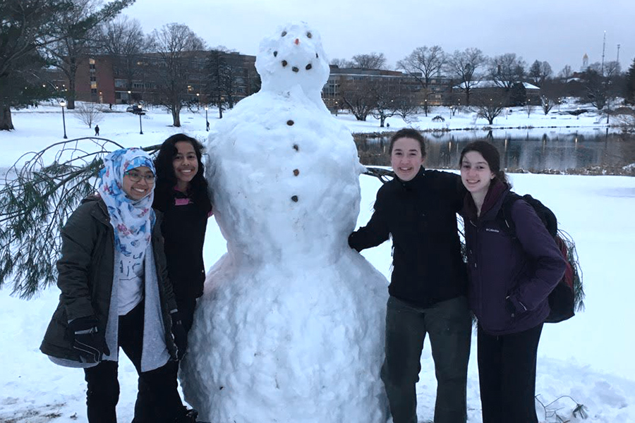 group posing with a snowman